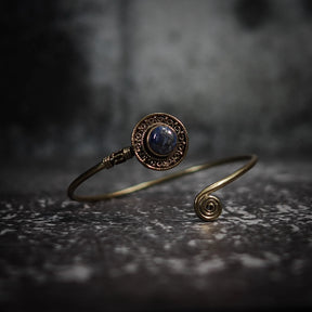 Justerbar armband med mörkblå labradorit sten, dekorativ mässings­behållare och antik-inspirerad filigren-arbete.