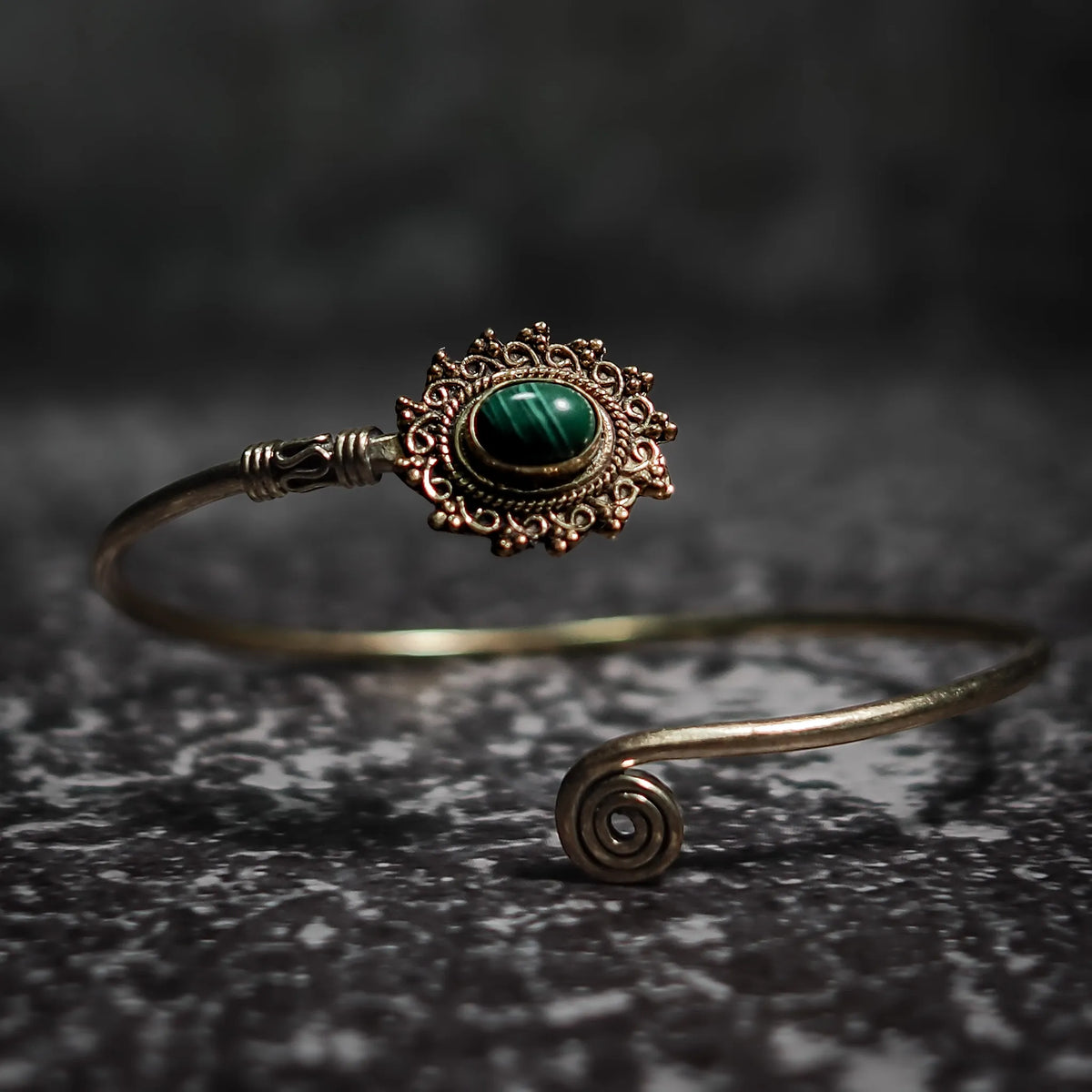 Vikingarmband i turkos oval design med dekorativ filigre innfattning och spiralformad terminal på mörk sten