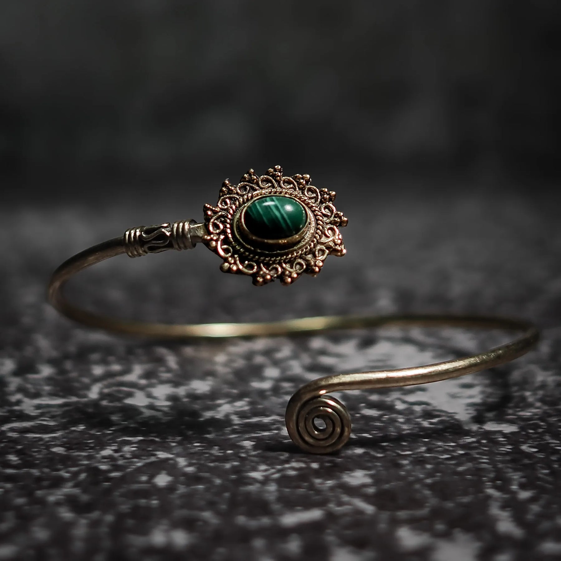 Vikingarmband i turkos oval design med dekorativ filigre innfattning och spiralformad terminal på mörk sten