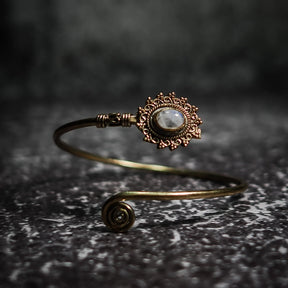 Vikingarmband i vit/grå halvädelsten med ornamenterad filigre och spiralformad terminal på texterad bakgrund
