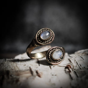 Spiralring i mässing med två svarta labradoriter i snirklade fasetter, på trä