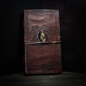 Brunt lädernotisar med vikingmönster och labradorit-kristall, fullständig bok-vy