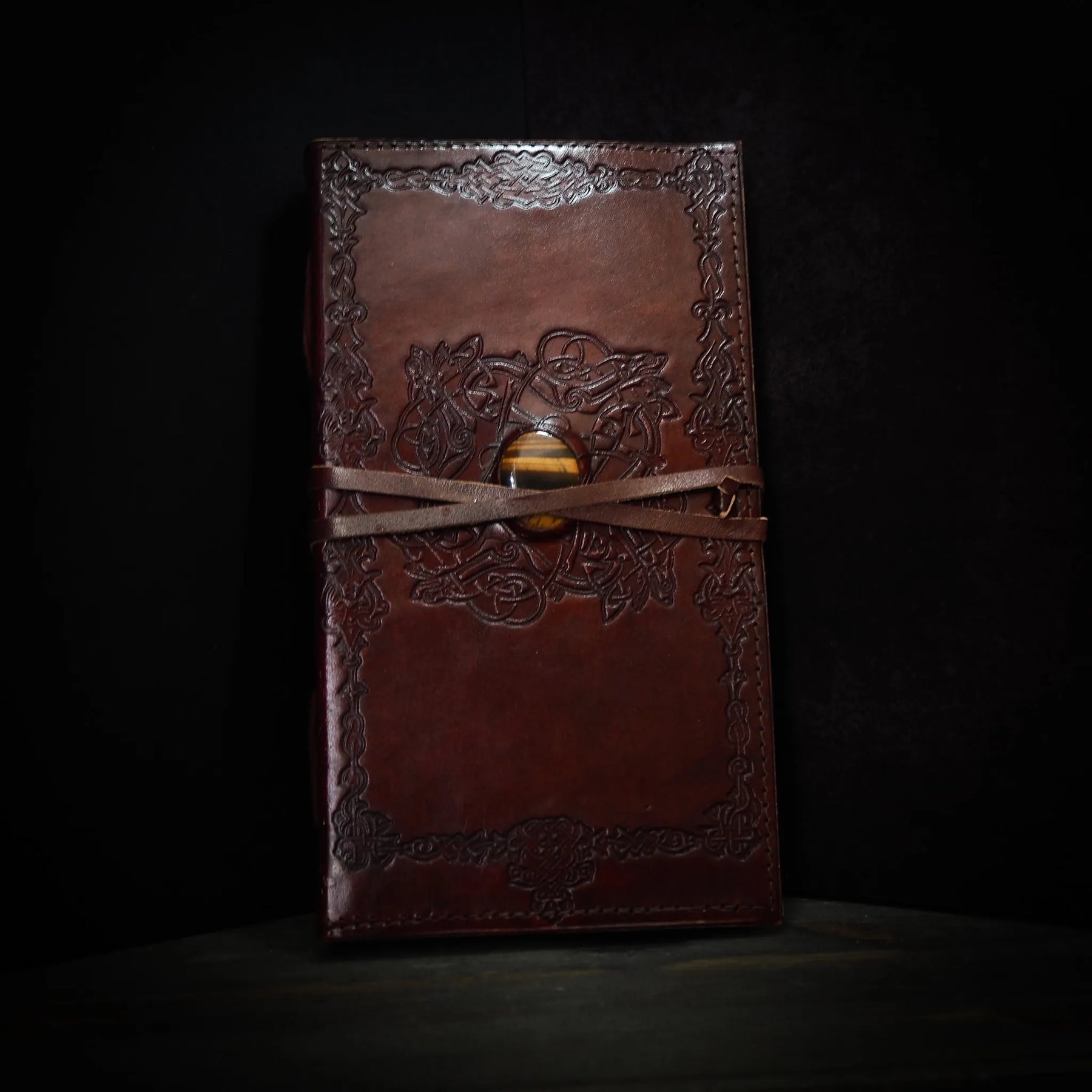 Brunt lädernotisar med vikingbroderi och tigeröga-kristall