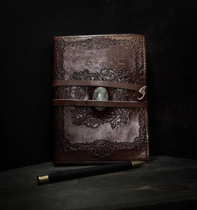 Handgjord läderbok Kristall i medium med moss-agat-sten. Brunt präglat läder med vikingmönster, grön moss-agat-sten i center och två läderband.