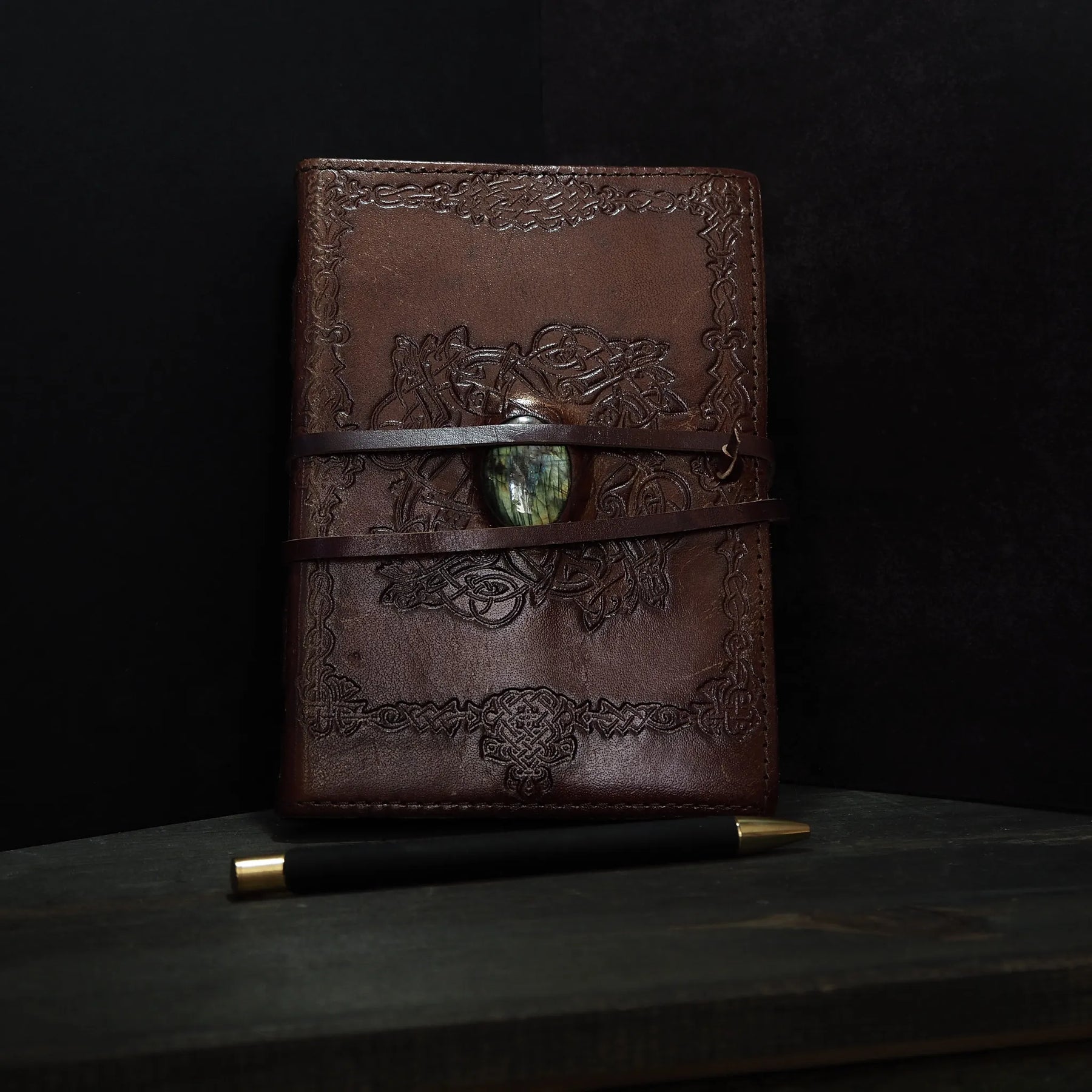 Handgjord läderbok Kristall i medium med moss-agat-sten. Burgundibrunt präglat läder med vikingdekor, pale grön moss-agat-sten och två bruna läderband.