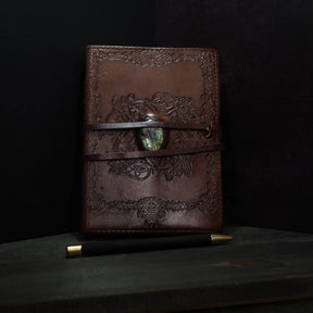 Handgjord läderbok Kristall i medium med moss-agat-sten. Burgundibrunt präglat läder med vikingdekor, pale grön moss-agat-sten och två bruna läderband.