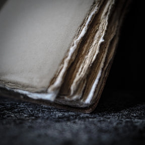 Närbild av anteckningsbokens pärm visar lagret av handgjort bomullspapper med synlig fibertextur