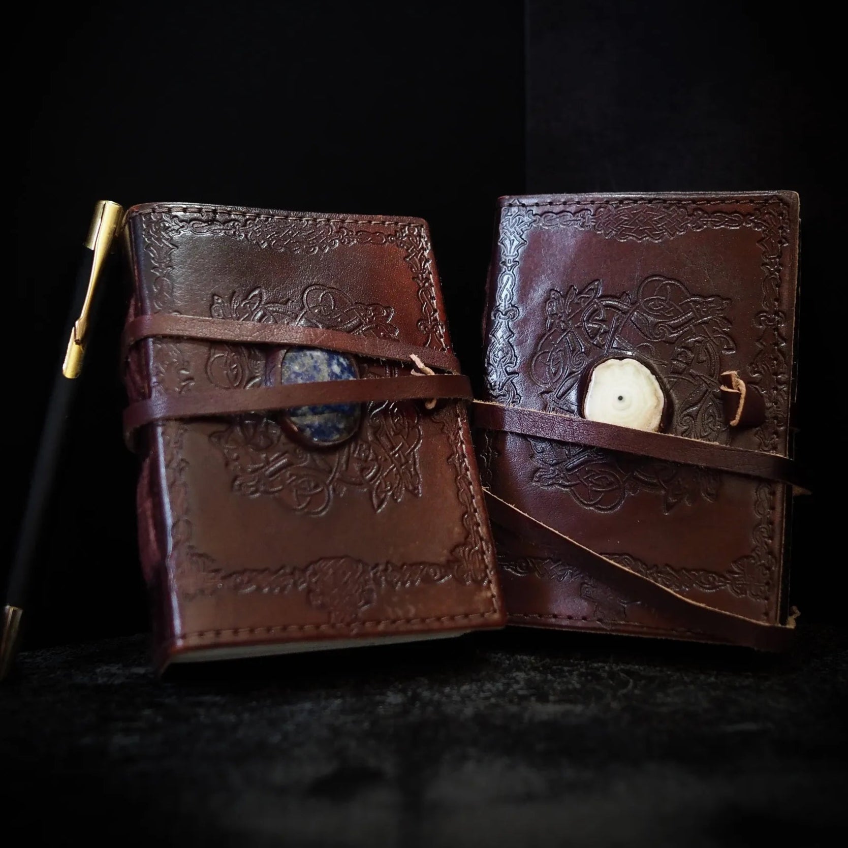 Liten läderbok Kristall öppen, visar brunt skinn med vikingamönster och inlagd Lapis Lazuli-sten på insidan