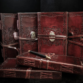 Handgjord läderbok Kristall i stor med rosenkvarts-sten. Burgundibrunt präglat läder med vikingmönster, ljusrosa rosenkvarts-sten i metallfattning och brunt läderband.