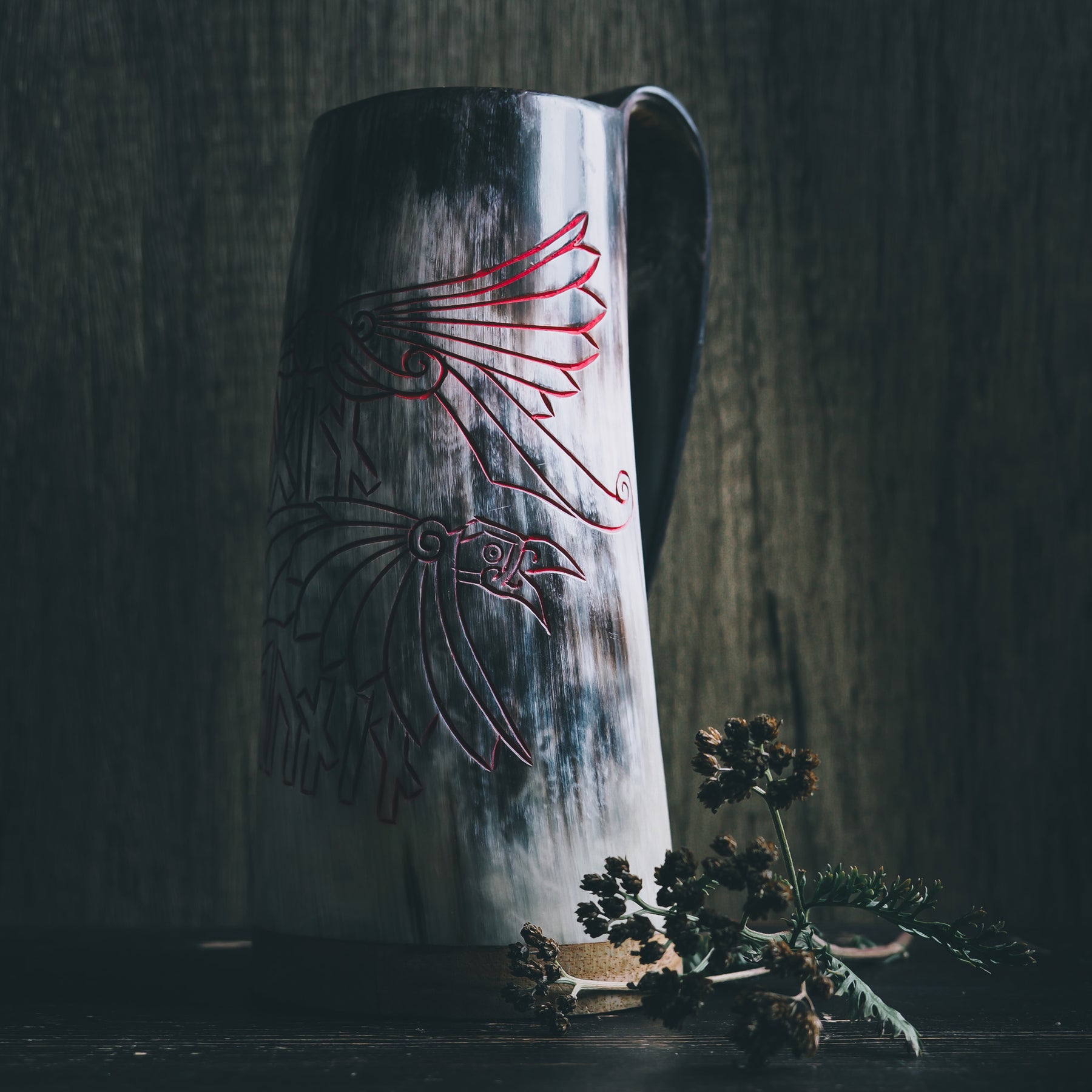 Hornöl mugg med graverad viking design. Två klassiska norska korpar (Hugin och Munin) med utspridna vingar och nordiska runor mellan dem. Naturlig hornfärg, ljus krämfärg. Dekorerad med torkade växter.