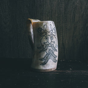 Ölmugg Odensmask, mugg visad från olika vinklar. Designen är tydligt synlig.