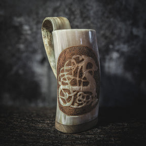 Hornmugg med Urnes drake-motiv fotograferad från tre-fjärdedelsperspektiv för att visa handtag och skärningens volym.