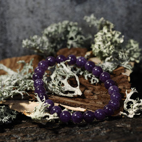 Armband stenpärlor - Tigeröga variant med ametist. Elastiskt armband med djupvioletta polerade ametist-pärlor på rustik träbas med mossbeväxt stenbackgrund.