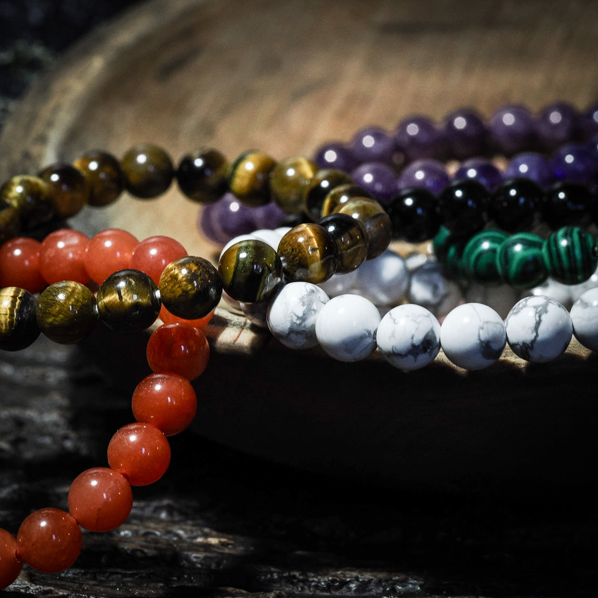 Armband stenpärlor - åtta varianter. Produktkollage visar olika armbandsdesigner med polerade runda stenpärlor i olika stenar: tigeröga, karneol, ametist, svart turmalin, vit marmor, grön malakit och andra naturstenar. Alla pärlor är symmetriska och högt polerade.