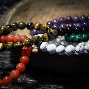 Armband stenpärlor - åtta varianter. Produktkollage visar olika armbandsdesigner med polerade runda stenpärlor i olika stenar: tigeröga, karneol, ametist, svart turmalin, vit marmor, grön malakit och andra naturstenar. Alla pärlor är symmetriska och högt polerade.