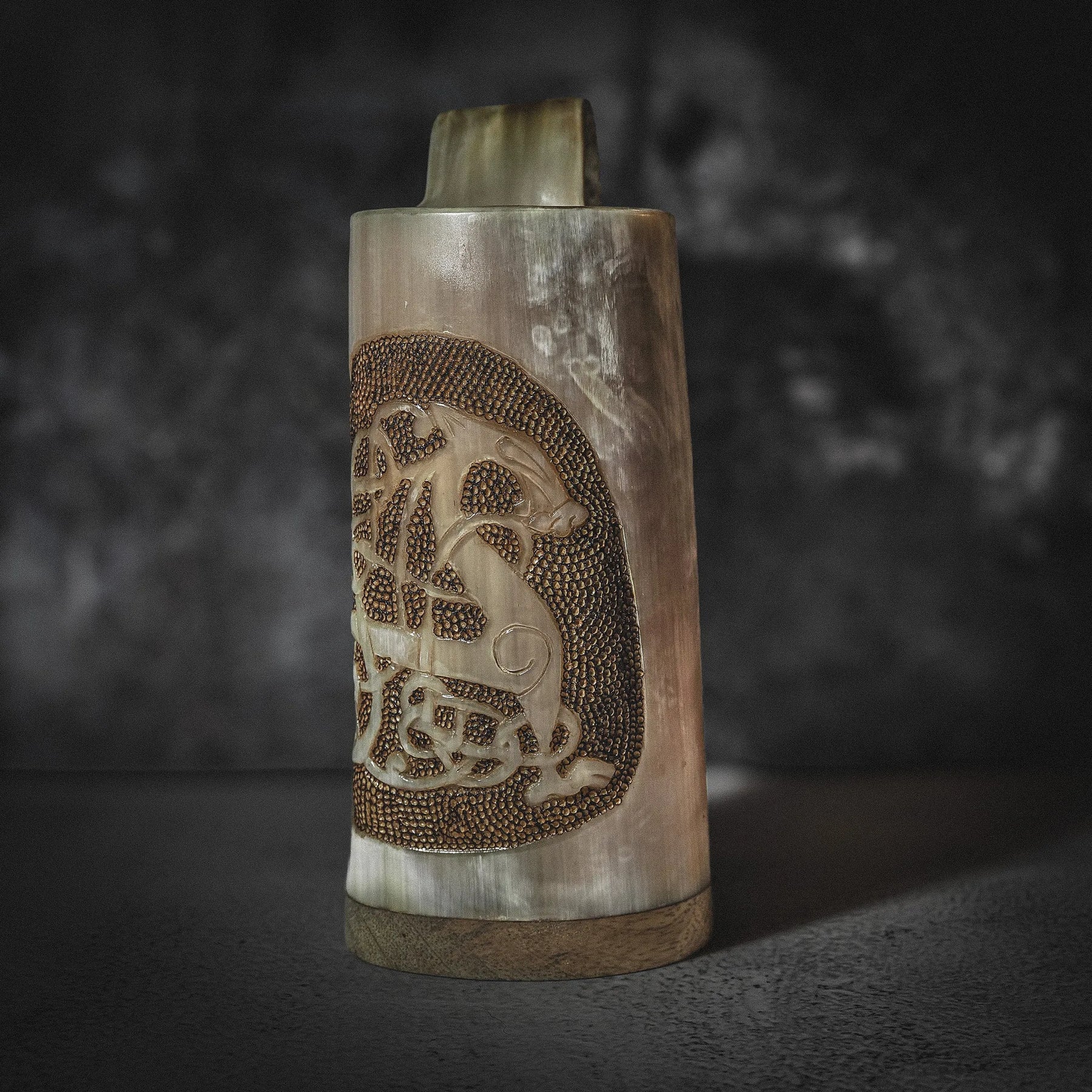 Handsnidad hornmugg i frontvy med djupskuren Urnes-drake och pyrografi-mönster. Organic horn i naturliga kräm- och bruntonanger, sett mot neutral bakgrund.