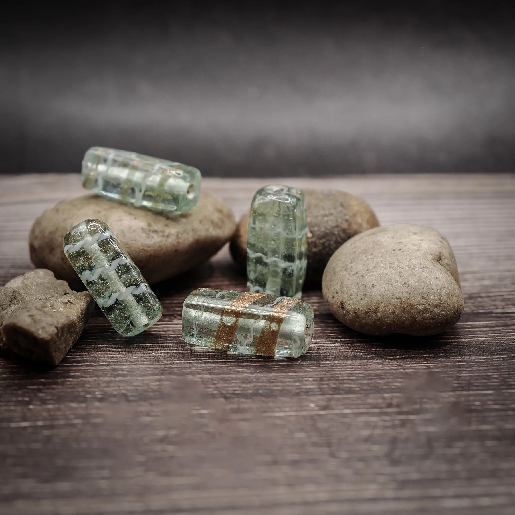 Mintgrön glaspärla med metallisk dekordetalj, cirka 22mm rektangulär form, på naturlig stenbakgrund