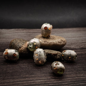 Silverfärgad glaspärla med prickar, produktbild visar designen och materialet.