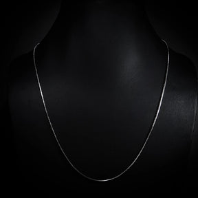 Silverfärgad kirurgisk stålkedja 55cm lång med slang-mönstrad länkstruktur, visad som fullständigt halsband mot mörk bakgrund