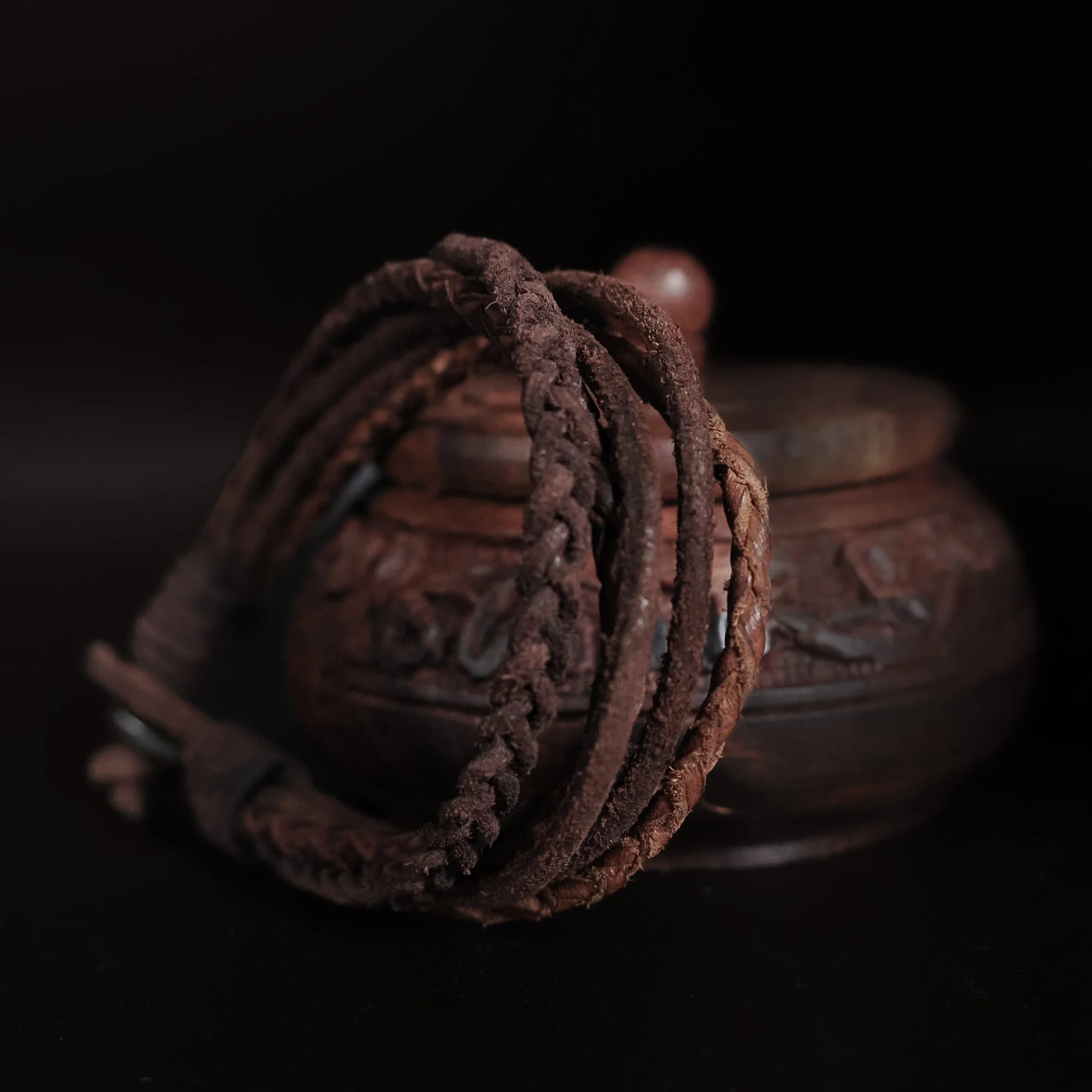 Läderarmband i brunt med flera flätade läderband, uppspänd för att visa konstruktion och längd