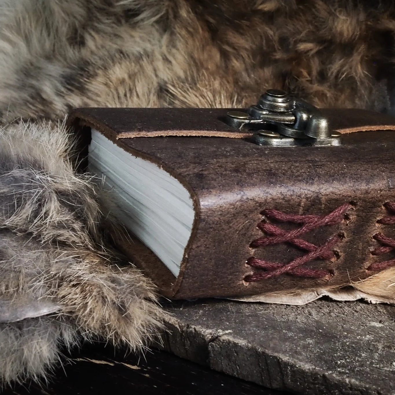 Läderbok med krok - vintage läderjournal med metallkrok och hantverk, fotograferad på trä med naturliga rekvisita