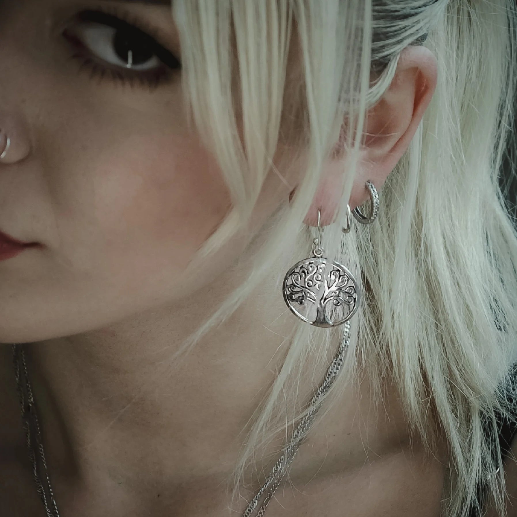 Guldpläterade Yggdrasil/Livets träd örhängen på ornamental mässingsställ med träbakgrund