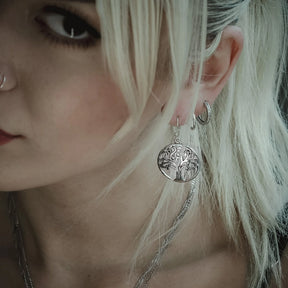 Guldpläterade Yggdrasil/Livets träd örhängen på ornamental mässingsställ med träbakgrund