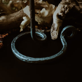 Närbild av Lavatein ljusstake i hand-smiddat järn, visar detaljerna i spiralformningen och patina på den galvaniserade ytan. Synliga smidesmärken framhäver autentisk vikingsk hantverk.