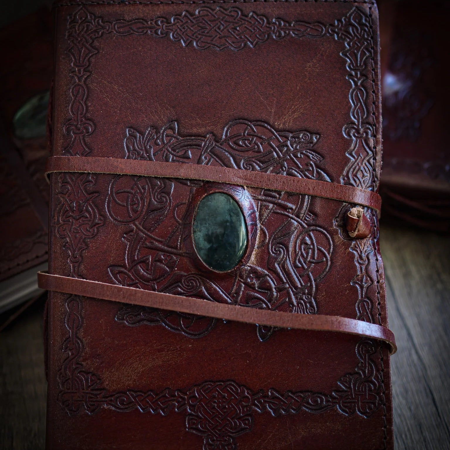 Handgjord läderbok Kristall i medium med moss-agat-sten. Brunt präglat läder med vikingmönster, pale grön moss-agat-sten med dendritiska mönster och brunt läderband.