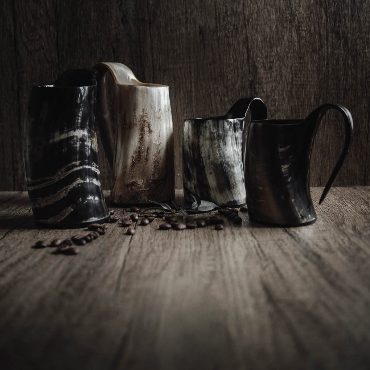Stort kaffekrus i horn – fire krus i forskellige mønstre ved siden af kaffebønner på træ