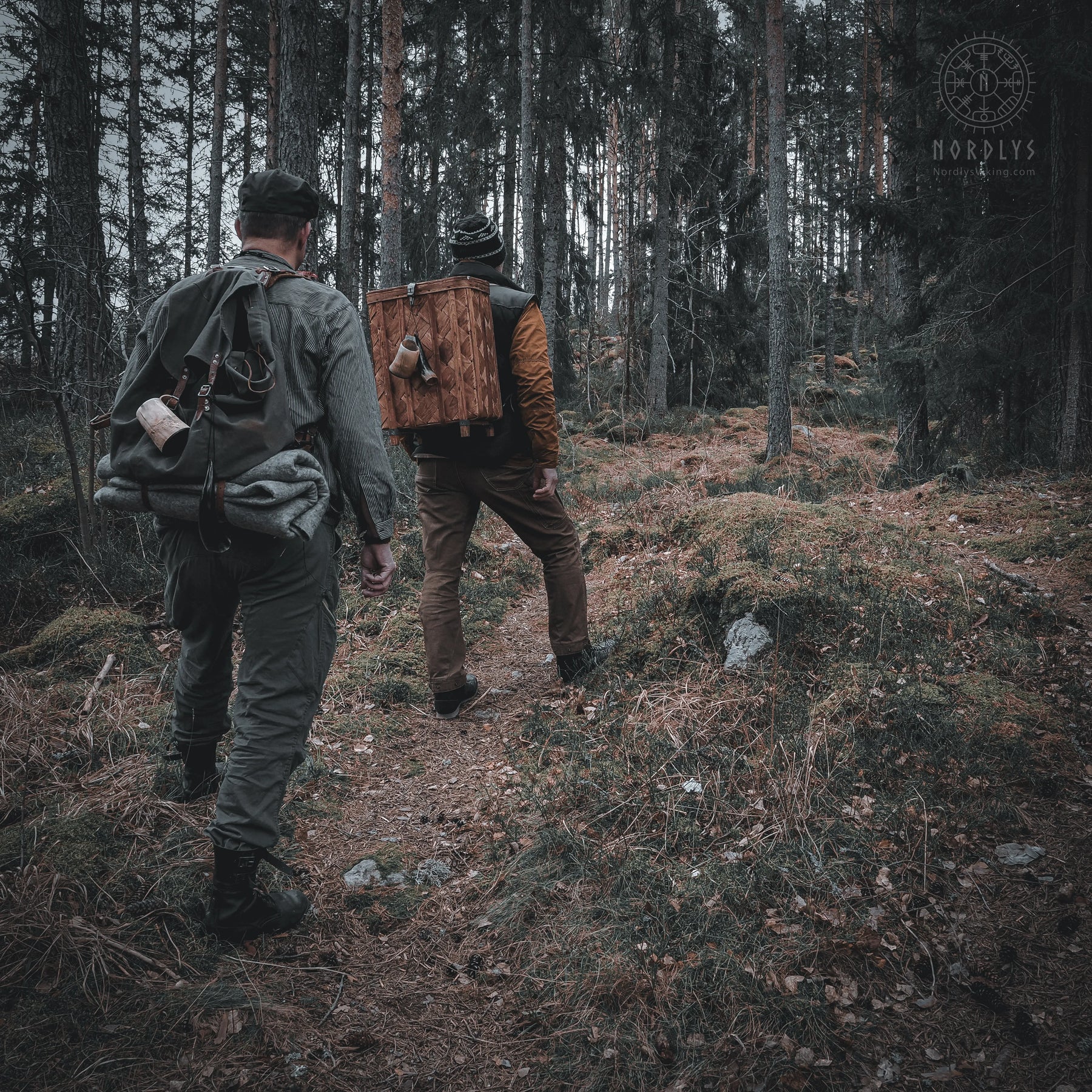 Two people seated outdoors at night using handfelted wool blankets for warmth, demonstrating outdoor camping use