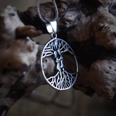 Ask och Embla-amulett i silver på tjock silverkedja, fotograferad mot mörkad trägarn för att visa autentisk nordisk mytologistil