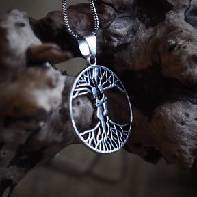 Ask och Embla-amulett i silver på tjock silverkedja, fotograferad mot mörkad trägarn för att visa autentisk nordisk mytologistil
