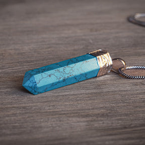 Stenhänge med Turkos - turkosblå färgad howlite på naturlig mossig skog trä, visar kristallens läknande energi