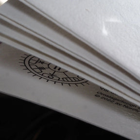Närbilds detalj av målarbok med fokus på papperskvalitet och bindning, visar tjocklek och textur.