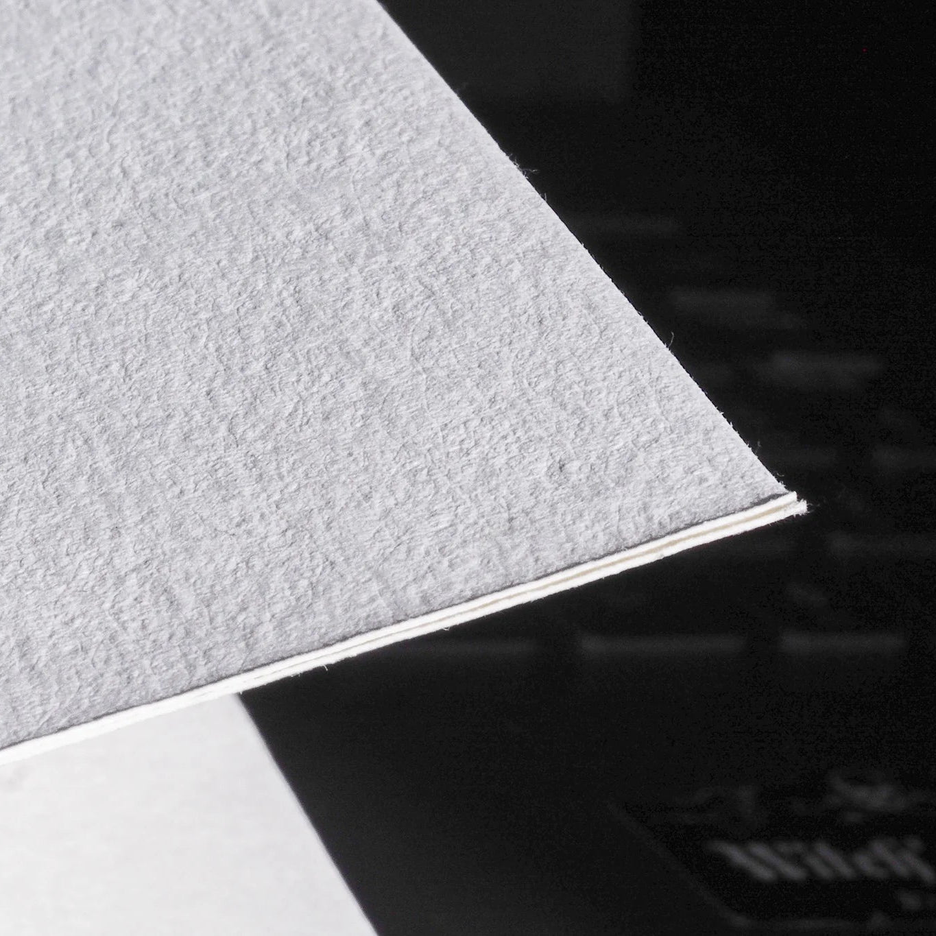 Detaljfoto av målarbok A6 med Skyddsruna Aegishjalmur. Närbild på bokens vitt akvarellpapper och rygg, fotad med högt kontrastljus för att visa materialkvaliteten.