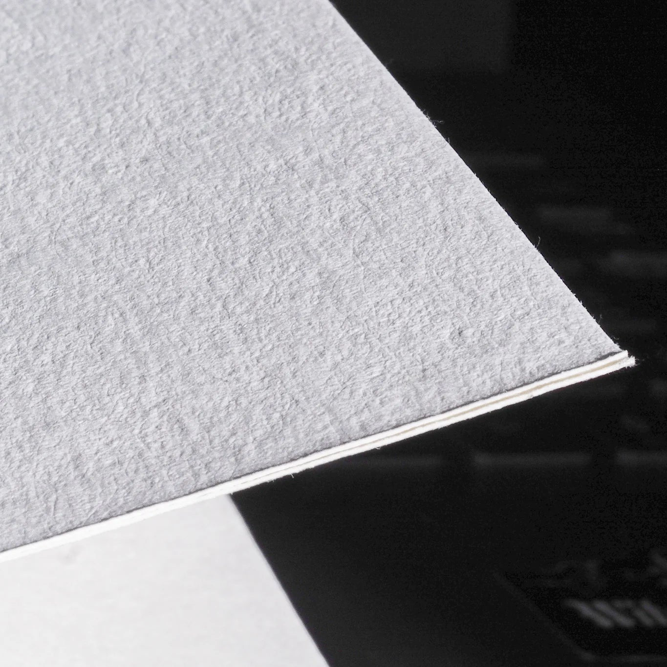 Närbild av återvunnen bomullspapers struktur och textur, visar fiber och håll kvalitet på 275g/m2