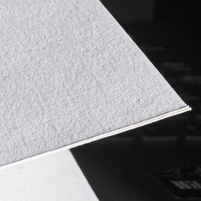 Närbild av återvunnen bomullspapers struktur och textur, visar fiber och håll kvalitet på 275g/m2