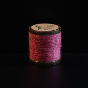 Rød broderitråd på traditionelle trætromler med Nordlys-mærkning. Dyb rød farve inspireret af vikingedragter og traditionelt skandinavisk broderi.