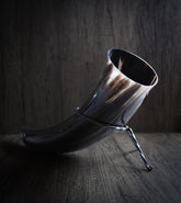 Polerad dryckeshorn med mörk finish fotograferad mot träbakgrund med dramatisk belysning, visar naturlig hornstruktur