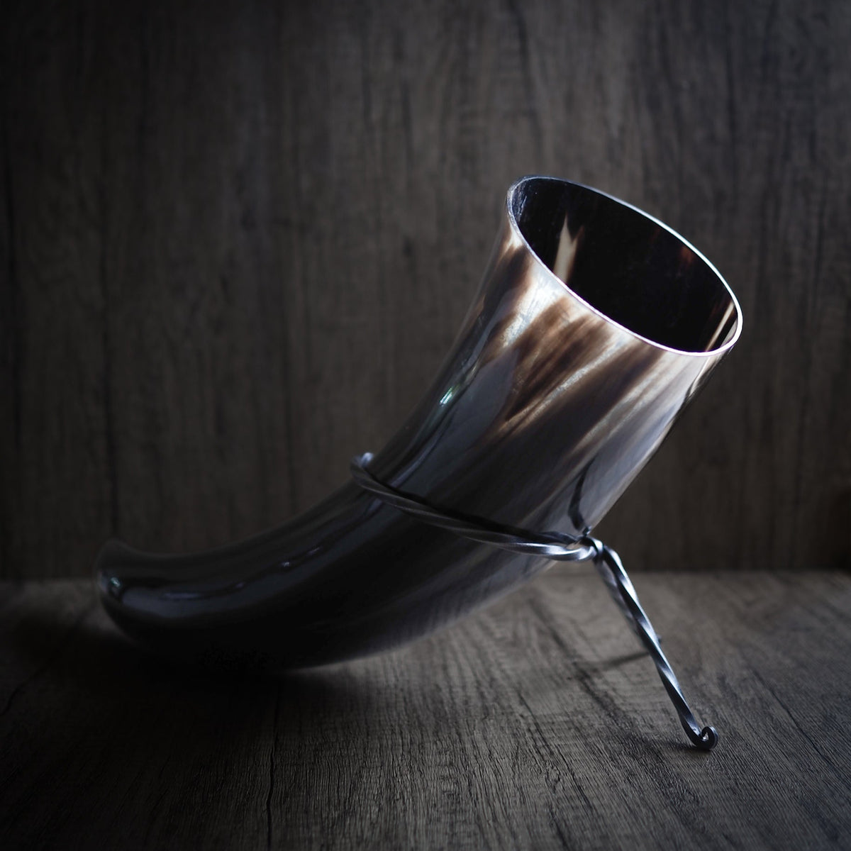 Dryckeshorn på 800 ml med handsmidett järnställ. Naturligt färgat horn med synlig kornstruktur och svartoxiderat järnställ med tripod-design för stabil placering.