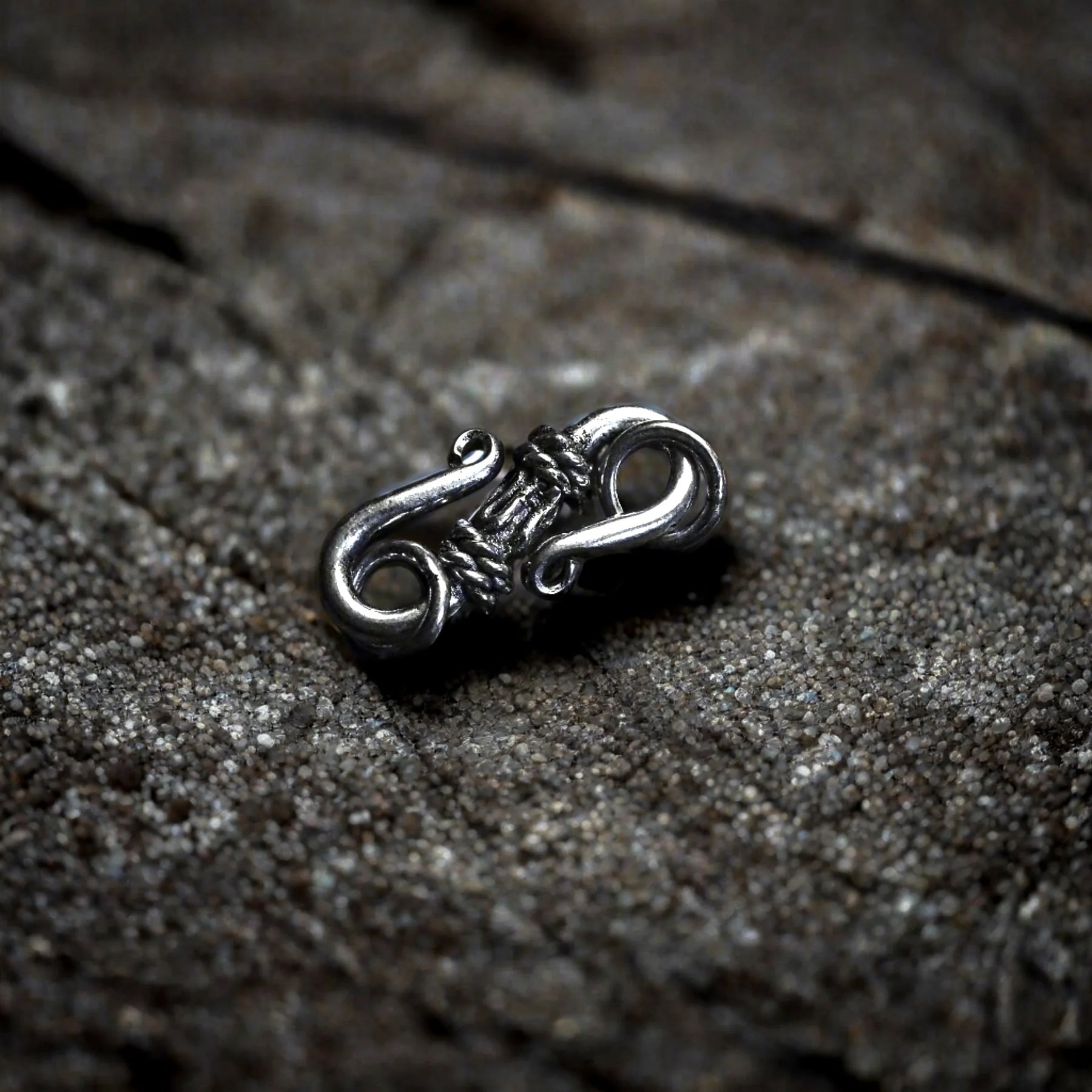 Smycklås i polerad silver med ornamental spiralmönster och filigranarbete. Dekorativt smycklås för halsband eller armband.