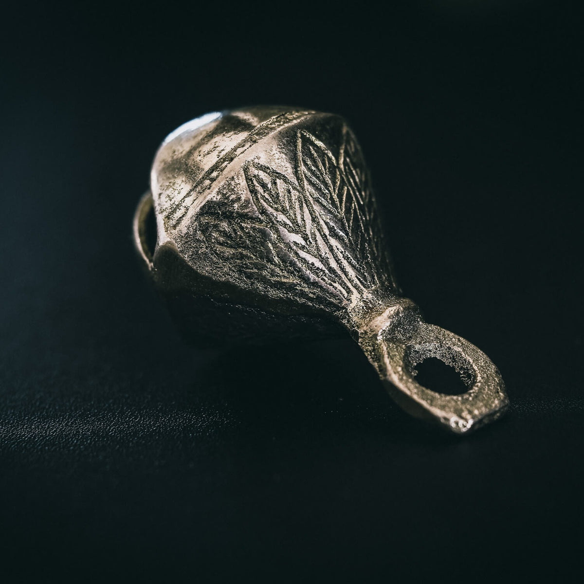Mässingbjällra 50mm Droppe varianten med fjedergravering och Viking design. Studio produktbild visar antik mässing och detaljerade mönster.