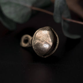 Mässingbjällra 40mm varianten Prickar med slitet utseende och antik patina. Isolerad studio produktbild på mörklagd bakgrund.