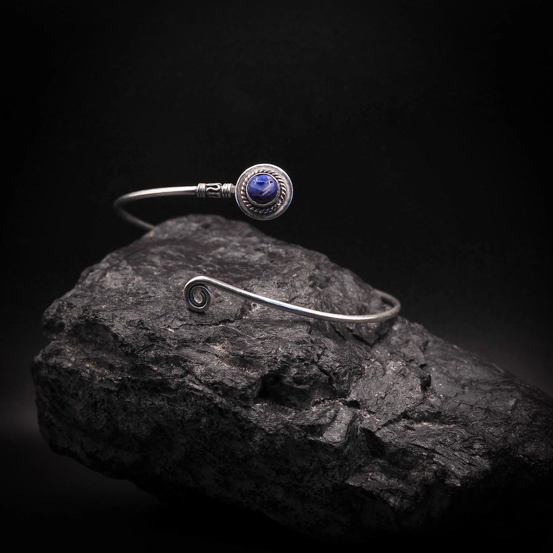 Adjustable upper arm ring with deep blue semi-precious stone in silver-plated brass bezel, decorated with ornamental wire wrapping
