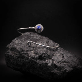 Adjustable upper arm ring with deep blue semi-precious stone in silver-plated brass bezel, decorated with ornamental wire wrapping