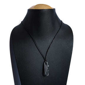 Eldstålshalsband på docka som visar hur pendanten sitter när den är på, med spiraldetaljer på järnet