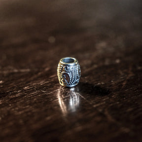 Liten skäggpärla av silverpläterad mässing med 9 mm längd och 4 mm dräthål för skägg och smycken.