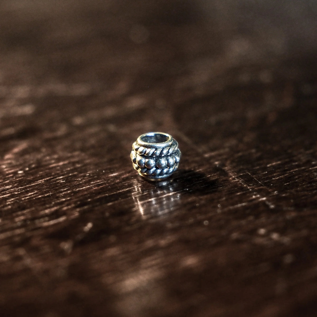 Silver-plated brass bead, 6mm long with twisted rope pattern decoration and 4mm hole for stringing