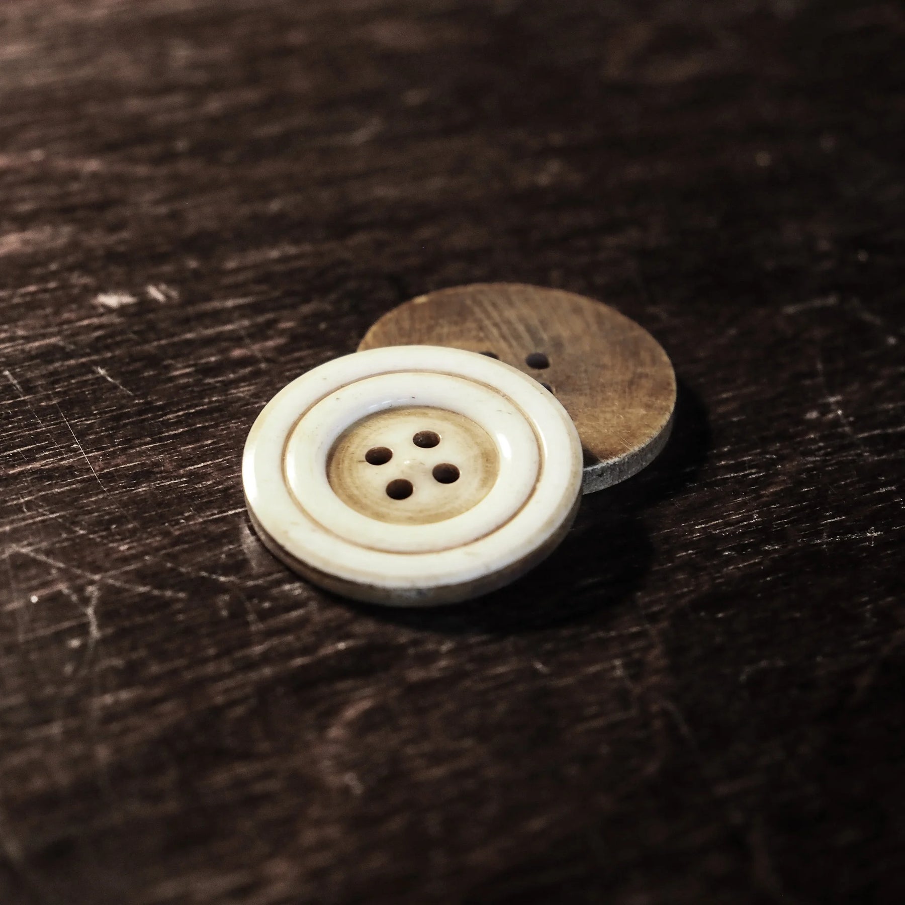 Stor benknapp, 30mm diameter, naturlig ben- och vallnötsfärg med synliga svarvarlinjer och fyra håll, handarbetet svarv-detaljer